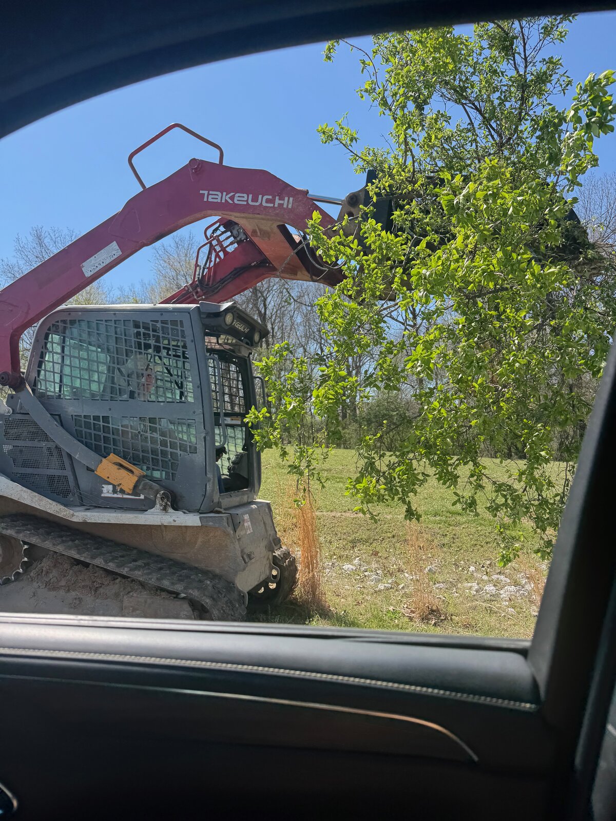 GHR skid steer with grapple attachment clearing brush